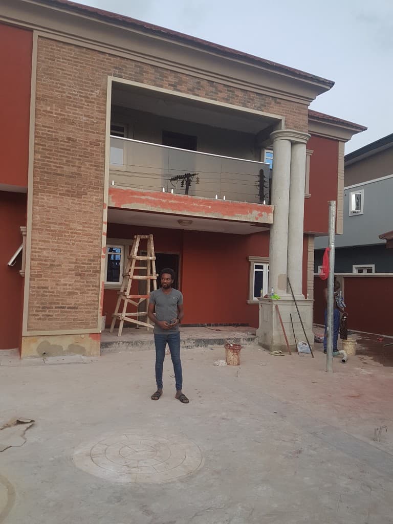 Terracotta two-storey home while finishing work continues around the balcony and forecourt